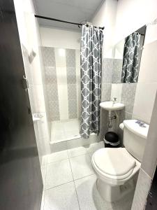 a bathroom with a toilet and a shower and a sink at Hotel Los Corales Mutata in Mutatá