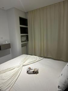 a white bed with a bottle on top of it at La Poupée in La Marsa