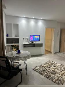 a living room with a table and a tv on a wall at La Poupée in La Marsa +7 photos