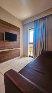 une chambre avec un lit et une télévision à écran plat dans l'établissement Apartamento Barretos Country Resort, à Barretos 6 autres photos