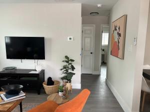 ダーラムにある7 Min walk to Golden Belt - 4 Min Drive to Downtown - 7 to Dukeの壁に薄型テレビが取り付けられたリビングルーム