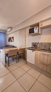 une cuisine avec une table et un comptoir dans l'établissement Apartamento Barretos Country Resort, à Barretos