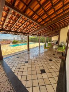 an outdoor patio with a wooden pergola at Casa em Escarpas do Lago in Capitólio