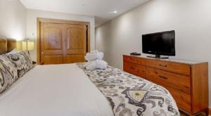 a bedroom with a teddy bear sitting on a bed at Luxury Ski In, Ski Out 2 Bedroom Mountain Residence In The Heart Of Lionshead Village With Heated Slope Side Pool And Hot Tub in Vail +15 photos