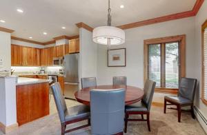 a kitchen with a dining room table and chairs at Luxury Ski In, Ski Out 2 Bedroom Mountain Residence In The Heart Of Lionshead Village With Heated Slope Side Pool And Hot Tub in Vail