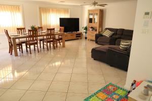 a living room with a couch and a table and chairs at Bella Callala Holiday Home in Callala Bay