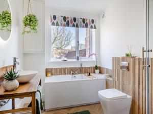 Un baño con bañera, inodoro y ventana. en Tower View - Uk48126, en Lincoln