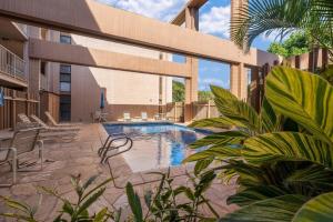 a swimming pool with chairs and a building at Kaleialoha 211 · KA 211 OceanFront 1BD Whale Watch Relax Getaway in Kahana