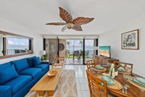 a living room with a blue couch and a table at Milowai 302 · MIL 302 Oceanfront 2BD w Ocean Views Whale Watch in Wailuku