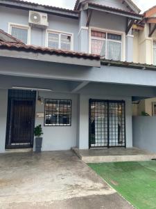 una casa bianca con cancelli neri e un cortile di Kajang Prima 2-story with 2 room 2 bath warm rooms a Kajang