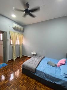 una camera da letto con un letto e un ventilatore a soffitto di Kajang Prima 2-story with 2 room 2 bath warm rooms a Kajang