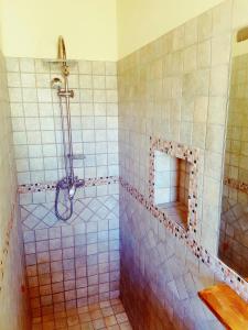La salle de bains carrelée est pourvue d'une douche et d'un miroir. dans l'établissement Agriturismo Gennemara B&B, à Perdaxius