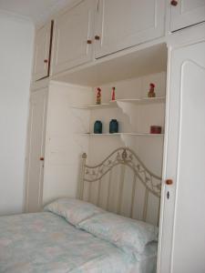 1 dormitorio con 1 cama con armarios blancos y estanterías en Brazil Cozy and Comfortable, en Río de Janeiro
