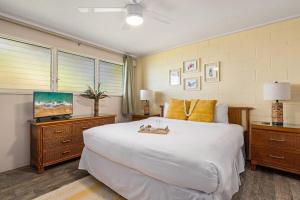 a bedroom with a large white bed and a flat screen tv at Maui Sands Seaside 713 · MSS 713 Charming 1BD Near Beach in Kahana