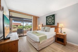 a bedroom with a large bed and a large window at Kaanapali Royal H101 · KRL H101 Remodel 2BD Condo Pool Kaanapali in Kaanapali