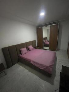 a bedroom with a large purple bed with a mirror at S2 JDC jardin de carthage in Tunis