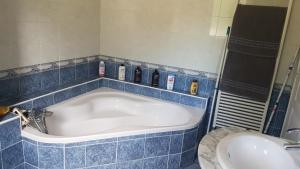Un baño con azulejos azules, bañera y lavabo. en Shanaël, en Gap