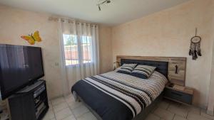 Un dormitorio con una cama y un televisor de pantalla plana. en Shanaël, en Gap
