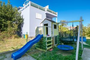 a playground in front of a house with a slide at Apartments with parking space Kastel Stafilic, Kastela - 24155 in Kaštela
