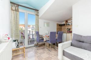 a living room with a couch and a table with chairs at Apartments with parking space Kastel Stafilic, Kastela - 24155 in Kaštela