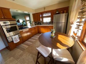 a kitchen with a wooden table and a refrigerator at Bohemian Oasis in Cudahy