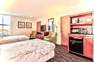 a hotel room with a bed and a microwave at Brunswick Suites Golden Isles Gateway I-95 in Brunswick