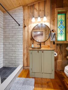a bathroom with a sink and a mirror at Honeymoon Cabin in McEwen