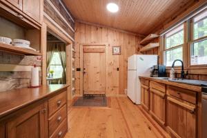 a kitchen with wooden cabinets and a white refrigerator at Honeymoon Cabin in McEwen +31 photos