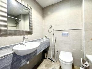 a bathroom with a sink and a toilet and a mirror at Signature Horizon Studio with Boulevard Views in Dubai +11 photos
