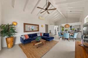 ein Wohnzimmer mit einem blauen Sofa und einem Tisch in der Unterkunft Palm Piscadera · Ocean Views · Pool · Beaches in Dorp Sint Michiel