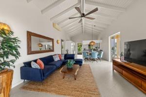 ein Wohnzimmer mit einer blauen Couch und einem Fernseher in der Unterkunft Palm Piscadera · Ocean Views · Pool · Beaches in Dorp Sint Michiel