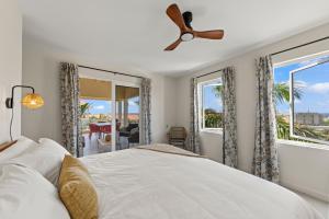 ein Schlafzimmer mit Bett und Deckenventilator in der Unterkunft Palm Piscadera · Ocean Views · Pool · Beaches in Dorp Sint Michiel + 47 Fotos