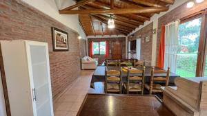 sala de estar con mesa y pared de ladrillo en Santa Clara Mar, en Frente Mar