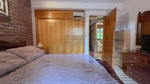 een slaapkamer met een bed en een houten deur bij Santa Clara Mar in Frente Mar +4 foto's