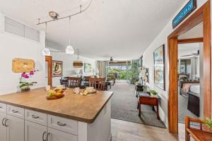 a kitchen with a counter and a living room at Eldorado E204 · EL E204 Lanai with View Pool AC Beach Cabana Gym in Kaanapali