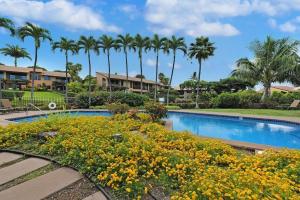 a swimming pool with yellow flowers and palm trees at Wailea Ekahi 21A · WEK 21A Remodeled Wailea Condo Pool AC Near B in Wailea