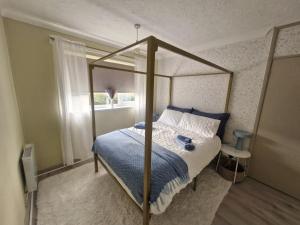une chambre avec un lit à baldaquin et une fenêtre dans l'établissement Modern Newly Renovated Home on the Broads, à Lowestoft 85 autres photos