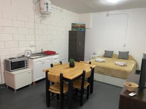 a small kitchen with a table and a bed at Sin Permiso Hospedaje in San Fernando del Valle de Catamarca