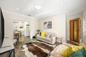 Glenungaにある4BR Home in Fullartonのソファとテーブルのあるリビングルーム