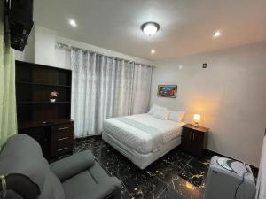 a hotel room with a bed and a couch at casa borde de lago in Panajachel
