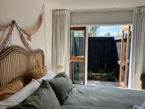 a bedroom with a bed and a sliding glass door at Tropical Escape near the beach with fire-pit & spa in Bowentown
