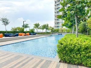 a swimming pool with orange chairs and a building at NEW Bt Kawan5 2BR Suite-IKEA-UOW KDU-ColumbiaAsia in Batu Kawan