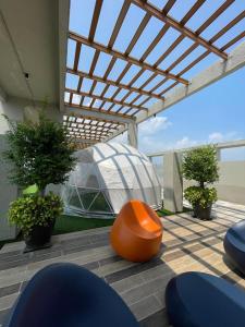 a patio with an orange chair and a glass house at NEW Bt Kawan5 2BR Suite-IKEA-UOW KDU-ColumbiaAsia in Batu Kawan