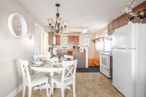 a kitchen and dining room with a white table and chairs at Grande maison moderne 4 chambres - Spa Jaccuzi, Jardin & Parking gratuit - Idéale Familles et groupes in Saint-Jean-sur-Richelieu