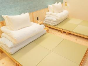 a room with two beds and pillows on a table at asterisk HIROSHIMA in Hiroshima
