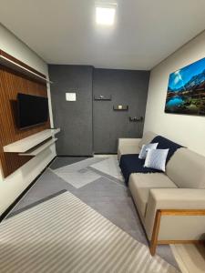 Una pequeña habitación con un sofá y un televisor. en Casa Praia da Fonte, en Guarapari