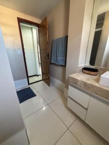 a bathroom with a sink and a mirror at Casa Praia da Fonte in Guarapari +31 photos