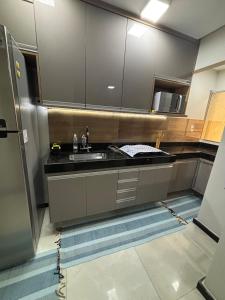 una cocina con fregadero y refrigerador en Casa Praia da Fonte, en Guarapari