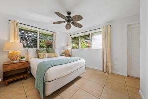 a bedroom with a bed and a ceiling fan at International Colony Club 37 · ICC 37 Remodeled Hawaiian Cottage in Kaanapali +57 photos