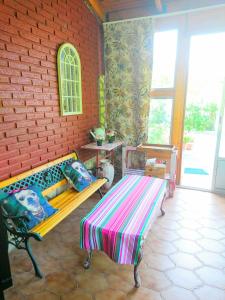 een kamer met een bank en een bakstenen muur bij Las Rosas in Pollos
